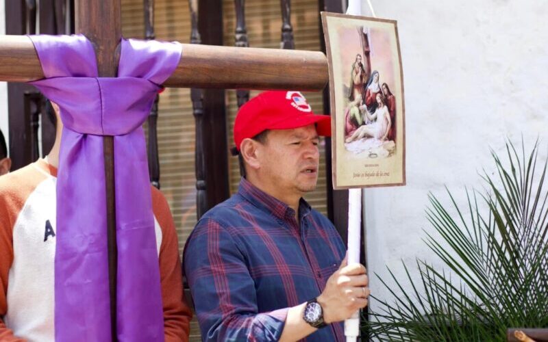 Procesión religiosa con vestimentas tradicionales por las calles empedradas de Pueblito